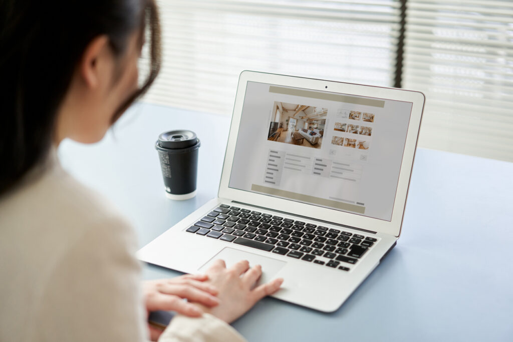frau betrachtet immobilieninserate auf laptop
