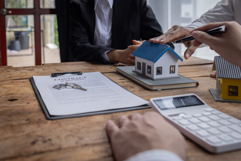 Immobilienmakler berät einen Kunden beim Kauf und Verkauf von Immobilien, erklärt Maklerprovision und hilft bei der Entscheidungsfindung zu Hypothekendarlehen und Hausversicherungen.